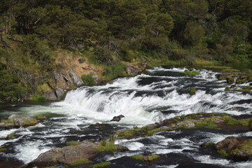 River flowing with green hills and blue sky