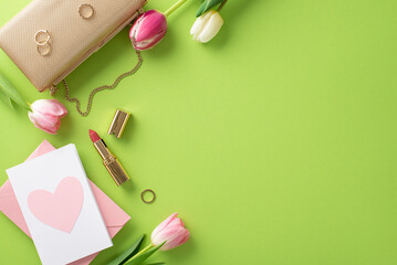 Graceful Mother's Day concept. Flat lay top view of handbag, postcard tulips, lipstick,and rings on pastel green background with a wide open space for text or advert