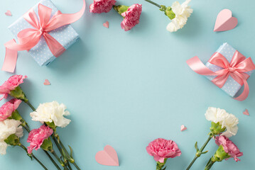Obraz na płótnie Canvas Mother's Day memories concept. Top view flat lay photo of gift boxes with pink ribbons, carnation flowers, and pink paper hearts on pastel blue background with empty space for text or advert