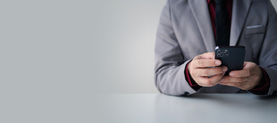 Cropped shot of young businessman using smartphone in the white modern office room.