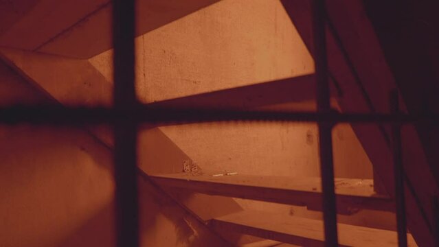 Empty jail cell. Prison. Horror or halloween concept. Orange electric light. Shadows