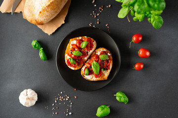 Bruschetta with Ricotto cheese and cherry Tomatoes, basil, garlic on a black background. Food. Food background. Top view