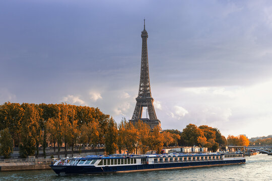 Boat sailing on the Seine in front of the Eiffel Tower on an autumn day