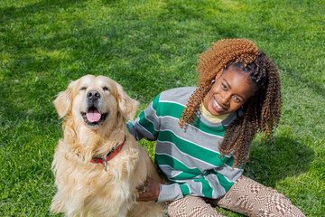 African girl playing with Golden Retriever dog
