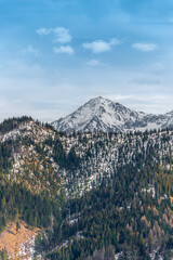 A beautiful mountain landscape in a vertical arrangement. Melting snow in the lower parts of the mountains. Snow-capped peaks. View from Rusinowa Polana. Early spring. Tatra Mountains, Poland © p  a  t  r  i  c  k