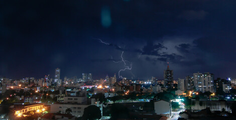 Thunderstorm with lightning in a cloudy sky over the high buildings of city SANTA CRUZ DE LA SIERRA - BOLIVIA