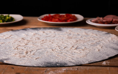 Ingredients for pizza or Italian food on a rustic wooden table. Onion, tomato, mozzarella cheese, peppers, pepperoni.