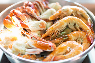 Steam blue crab legs and shrimp on food steamer.
