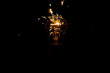 Light and sparks from a burning incandescent lamp. Short circuit.