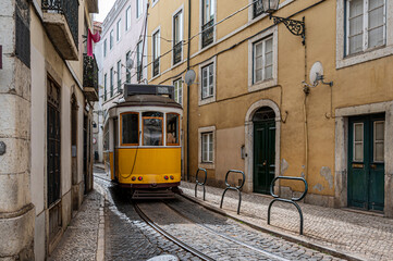 Retro yellow tram on narrow street in Lisbon, Portugal