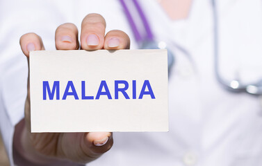 Doctor holding a white paper card with text MALARIA, medical concept.