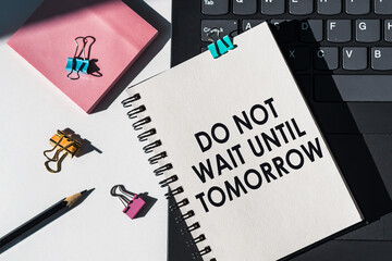 Do Not Wait Until Tomorrow text on notebook with keyboard