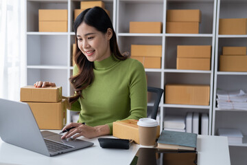 Young online shopping owner working in her shop, packing orders to customers.