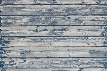 Blue panelled wooden fence or shed with peeling paint and space for copy