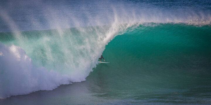 Surfer surfing a giant barrel wave, Barrack Point, Shellharbour, New South Wales, Australia