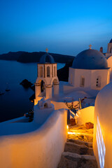 traditional greek village Oia of Santorini, with blue domes of churches at night, Greece