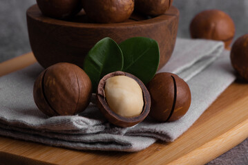 Organic Macadamia nut in wooden bowl and spoon. Superfood and healthy food concept.