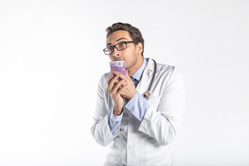 Funny and cunning doctor holding and sniffing pack of money isolated on white background. Corruption and bribe concept