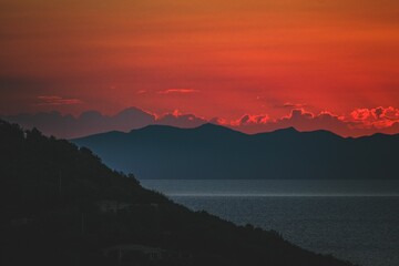 Beautiful view of a sea with mountains during orange sunset