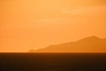 Beautiful view of a sea with mountains during orange sunset