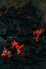 Coals with sparks in a huge old metal grill