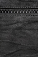 Crumpled black suede textured vertical background with black metal zip