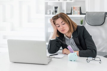 Close up photo of businesswoman and piggy bank with stuck banknote on desktop in the office