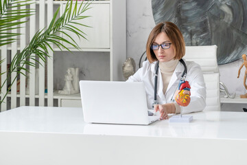 Portrait of young female doctor cardiologist working in office of modern clinic	 - obrazy, fototapety, plakaty