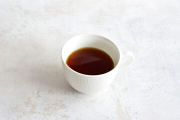 A cup of coffee sits on a marble table isolated, copy space 