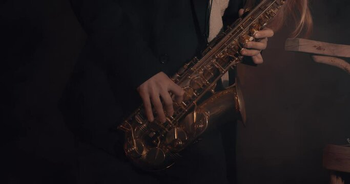 The camera shows the saxophone girl's fingers playing the saxophone