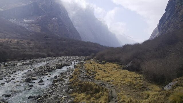 Flying through the wilderness along the Modi River in Nepal viewing a hiking trail below.