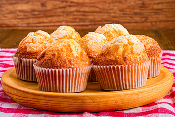 Delicious homemade muffins on a wooden plate