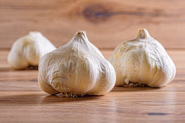 Three garlic. One of them in the foreground