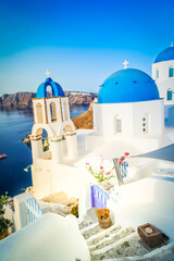 white church belfry, blue domes, steps and volcano caldera with sea landscape, beautiful details of Santorini island, Greece