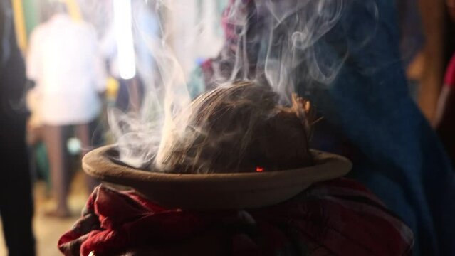 Traditional Hindu Dhunuchi footage with a lot of smoke. Holy worship elements video in Hindu religion. Clay pot with coconut husks and smoke. Hindu puja elements and Dhunuchi close-up footage.