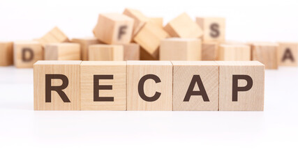 text RECAP made of wooden cubes and different words on white background