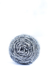 Cylindrical stainless steel scourer on a white background. Vertical.