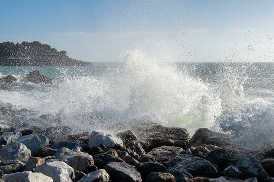 Wave splashing against rocks on the beach in Golfo dei Poeti (Gulf of Poets), Lerici, La Spezia, Liguria, Italy