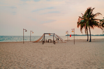 Candlelight Dinner romantisches Abendessen am Sand Strand bei Sonnenuntergang mit Laternen neben Palmen vor blauem Meer