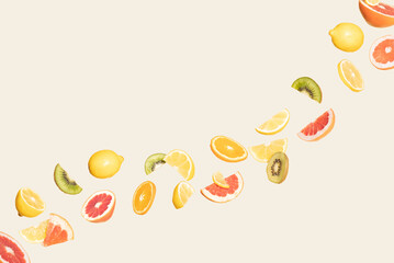 Colorful Summer citrus fruit flying on a cream background. Juicy aesthetic party concept. Orange, grapefruit, lemon, kiwi floating.