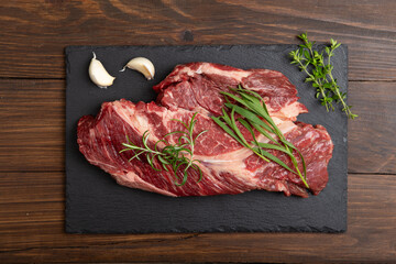 Raw beef steak on wooden table top. Healthy food concept. beef cut and spices for cooking bbq sauce