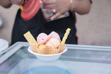 An Hispanic adult woman is preparing a traditional Mexican ice cream with cookies on a wafer