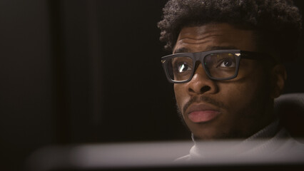 Face close up of African American man working or watching movie in studio with modern design. Film...