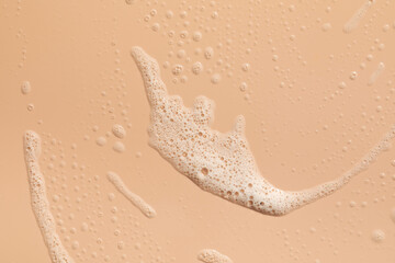 Foam texture on a pink background. A sample of facial foam. 