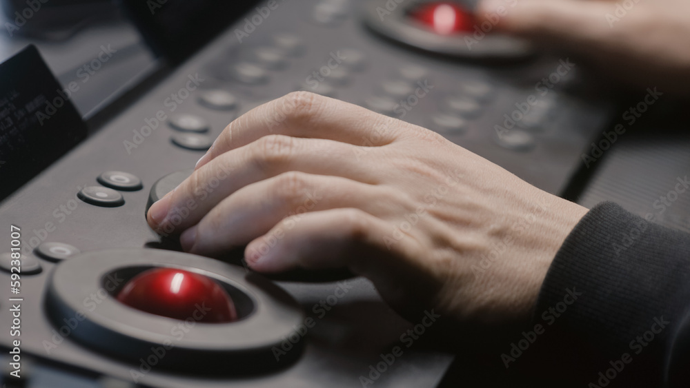 Poster the editor uses digital color grading control panel, presses buttons, changes settings. colorist mak