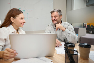 Young female talking with man in the office