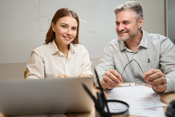 Obraz premium Smiling lady talking with male in the office