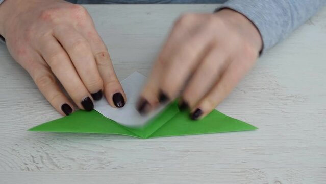 Step by step instruction how to make origami paper bookmark frog. Simple diy with kids children's concept. Step 2.