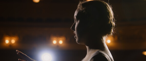 Close up portrait shot of ballerina discussing performance with partner on theater stage. Ballet...