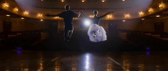 Pair of ballet dancers practice choreography moves on theater stage and prepare for theatrical...